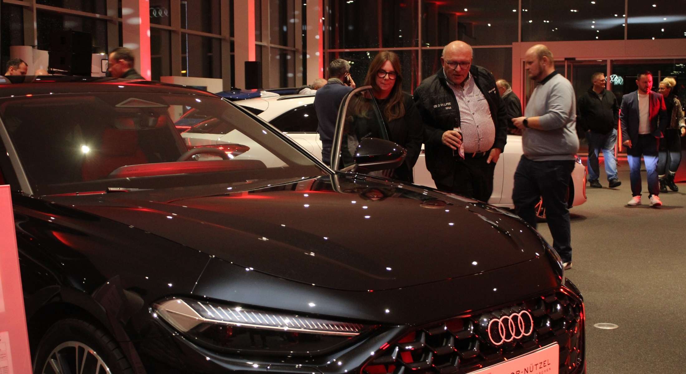 Fahrzeug im Vordergrund mit interessierten Besuchern