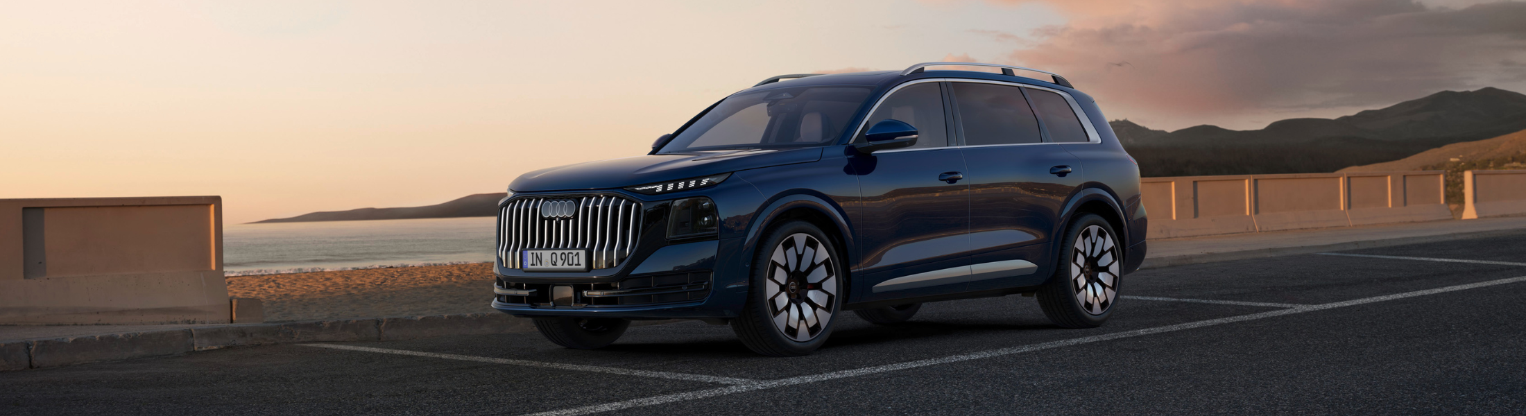 Audi Q9 von schräg vorne steht auf einem Parkplatz