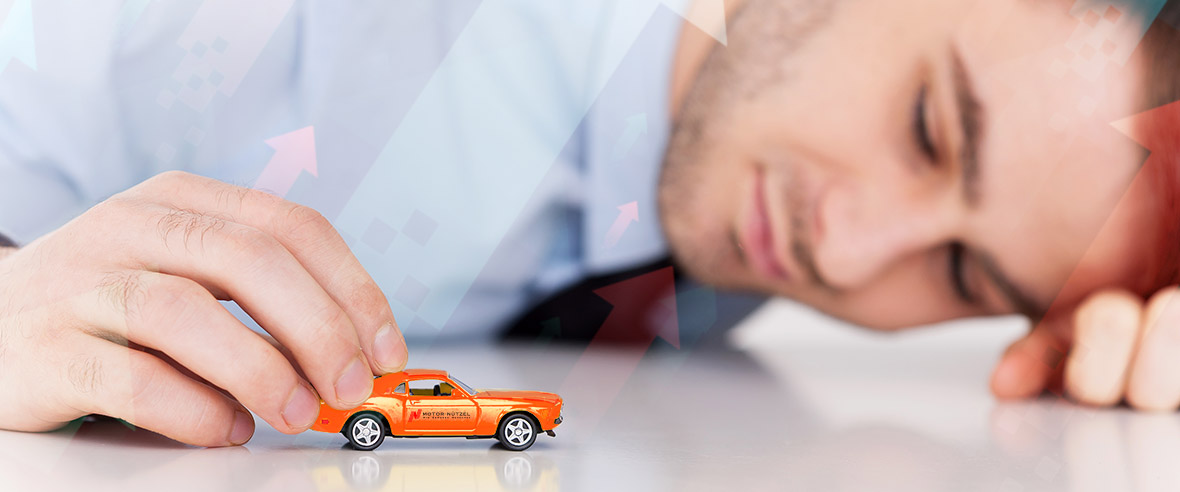 Mann spielt mit einem Spielzeugauto auf dem Tisch
