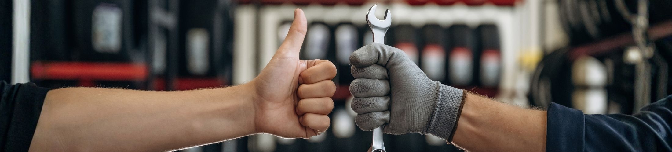 Hand mit Daumen hoch und Hand mit Schraubenschl&am