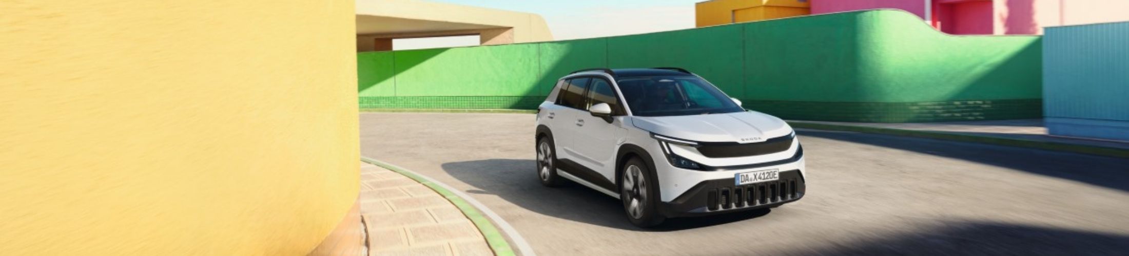 wei&szlig;er Skoda Epiq f&auml;hrt auf einer Stra&