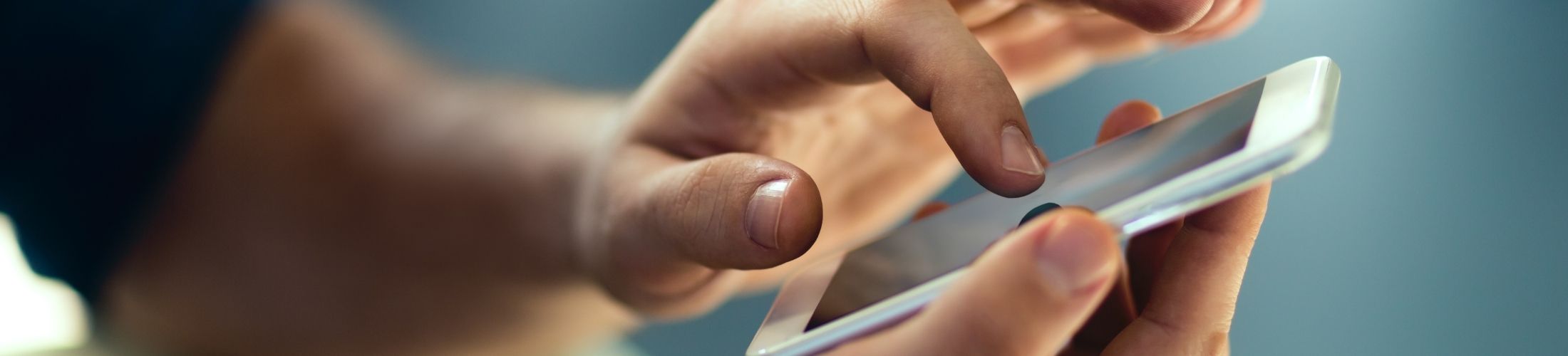 Eine Hand die auf ein Handy tippt